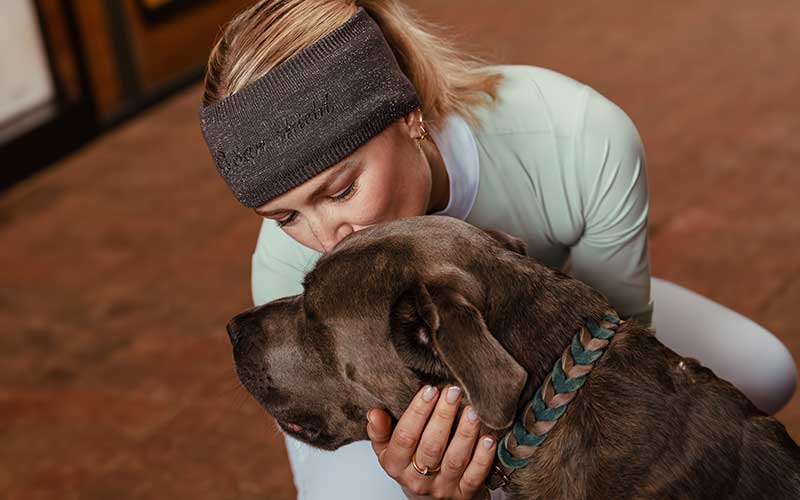 Mützen, Stirnbänder & Schals Frau mit Samshield Stirnband küsst Hund