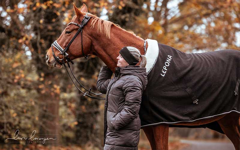 4. Aufwärmübungen vor dem Reiten Reiterin mit Pferd im Herbstlaub