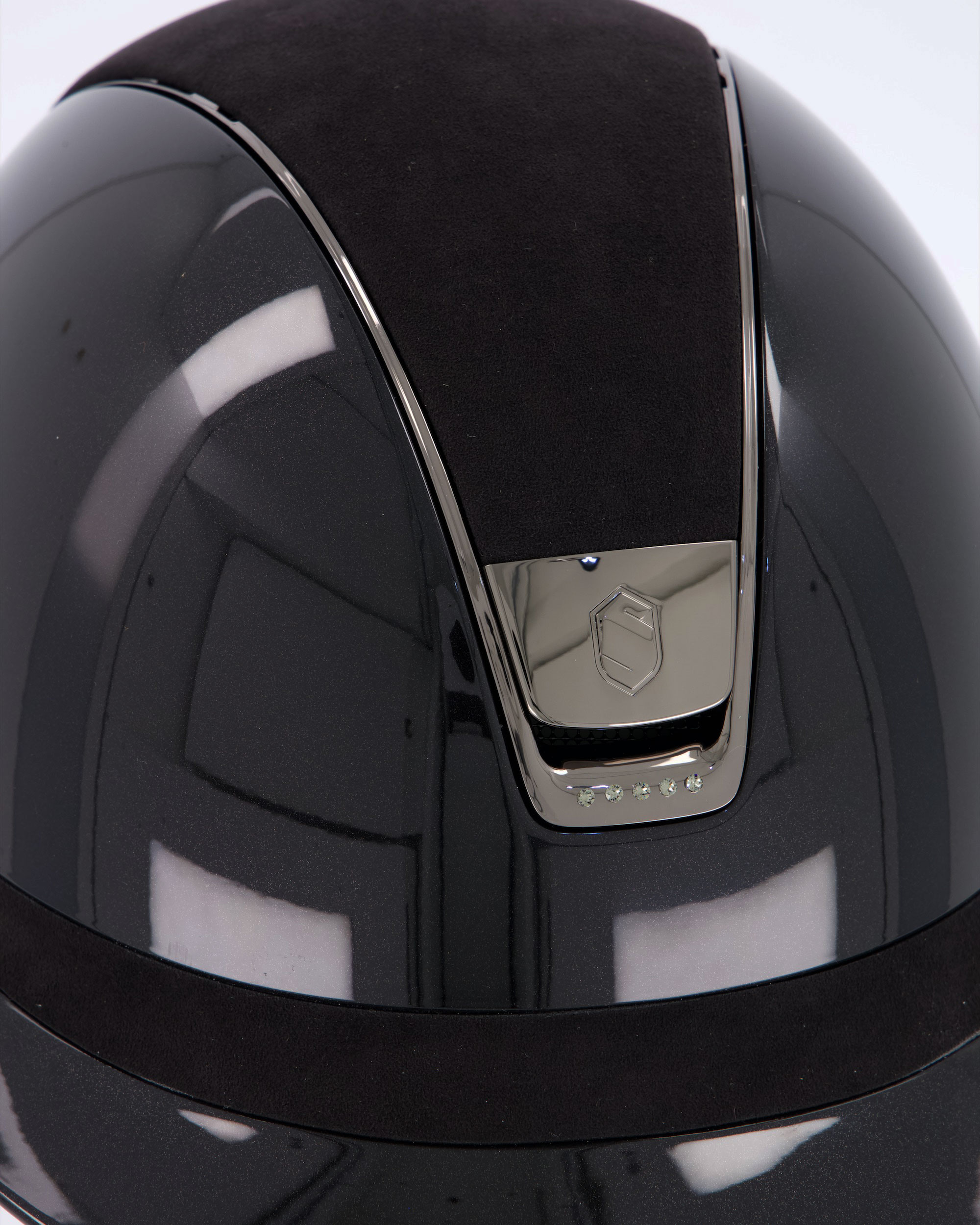 Riding helmet Miss Shield Shadowglossy Black, Top and frontal band Alcantara Black, Trim Matt Black, Blason Chrome Black, 5 Swarovski stones Black