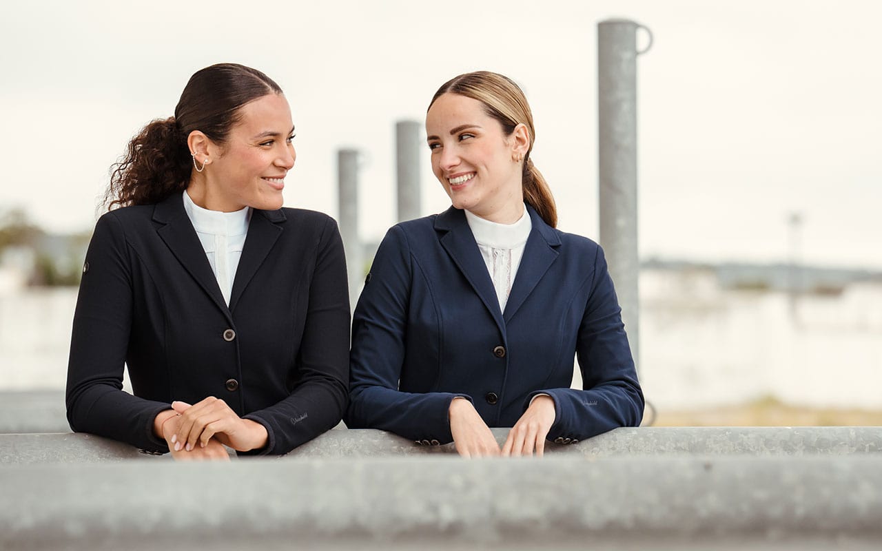 Alles fürs Turnier Zwei Frauen mit Turnierjacket lächeln sich an