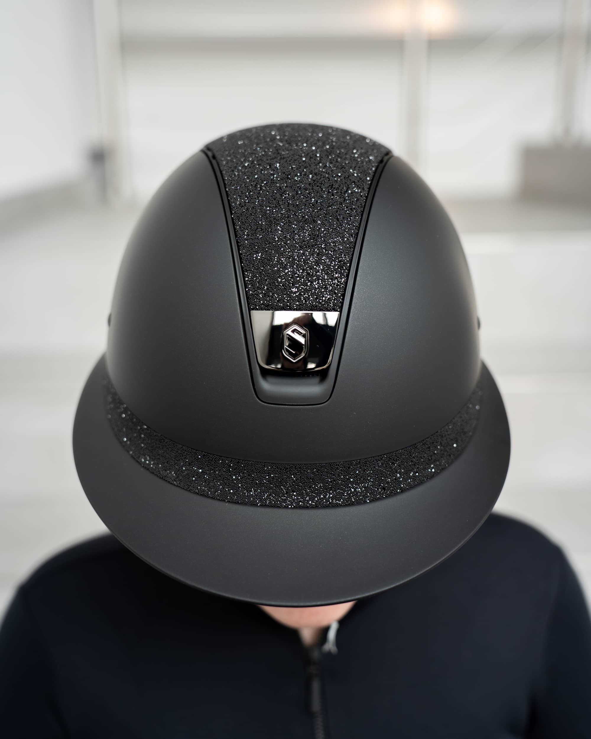 Riding helmet Miss Shield Shadowmatt, Top Crystal Fabric Swarovski Black, Frontal Band Crystal Fabric Swarovski Black, Trim Matt Black, Blason Chrome Black in black