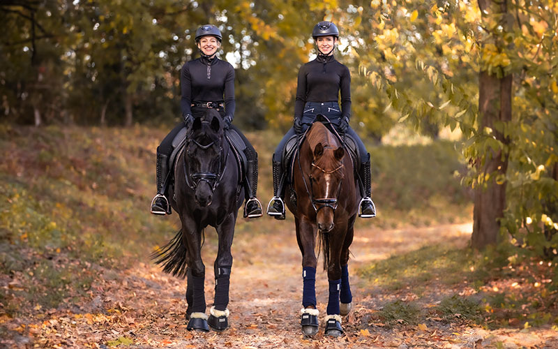 Waldhausen Reitsport Zwei Reiterinnen mit Waldhausen Artikeln auf Pferden im Wald